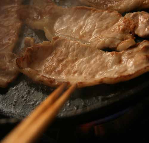 鉄フライパンで豚肉を焼く