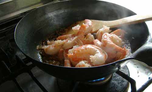 鉄フライパンでエビを焼く