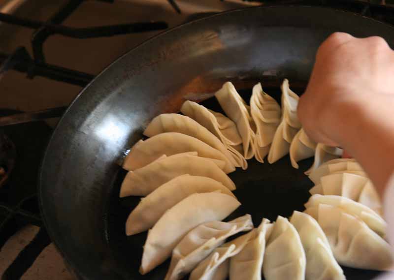 鉄フライパンに餃子を並べる