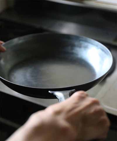 鉄フライパンをにぎっている